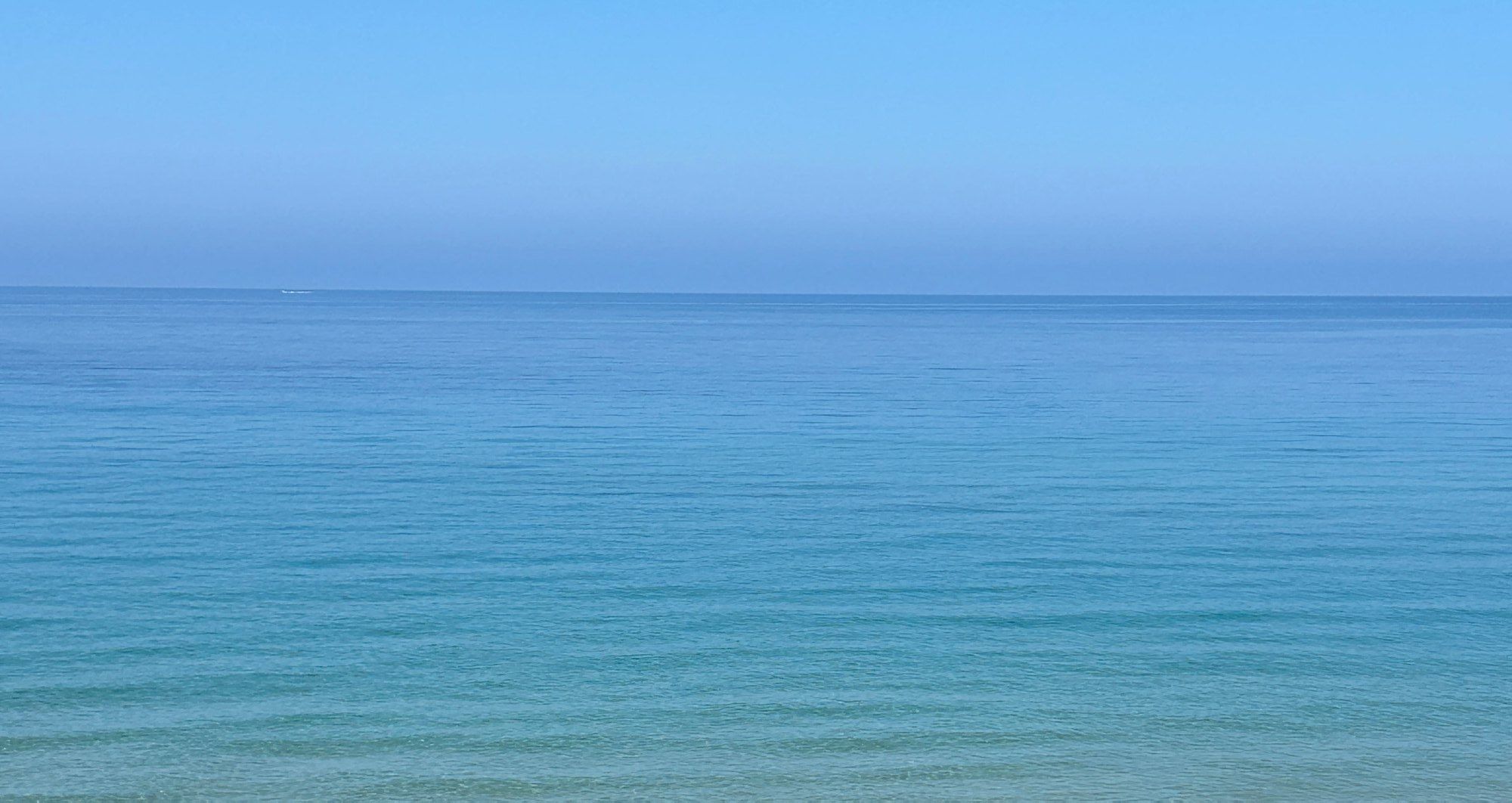 Il mare della Sardegna, azzurro e calmo, fino all’orizzonte